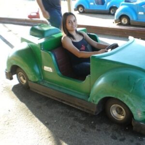 Woman in toy car smiling at camera